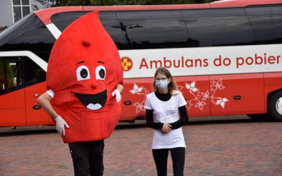 zdjęcie: 2 osoby na tle ambulansu do pobierania krwi